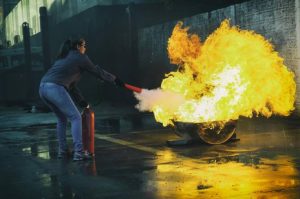 woman practicing fire extinguisher usage 